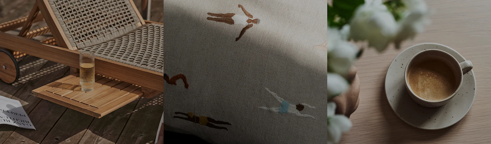 A sun lounger with a drink, an embroidered cushion with swimmers, and a coffee cup with white flowers.