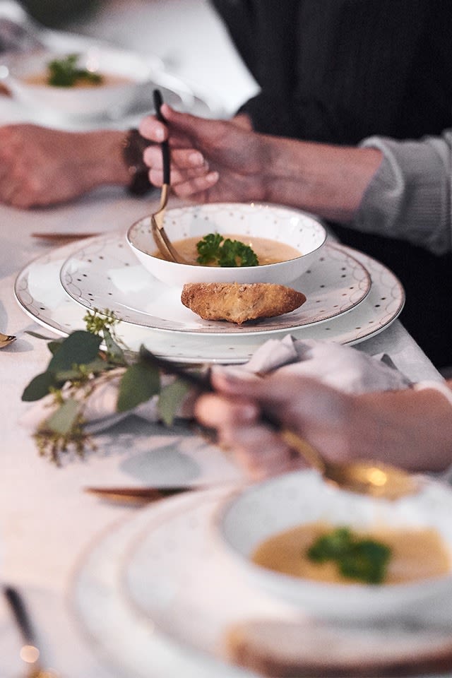 A Christmas table setting in white with bowls and plates from the Julemorgen series from Wik & Walsøe.