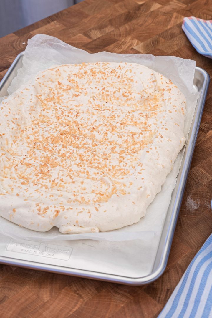 Bake a delicious meringue cake using Baka med Frida's simple Easter cake recipe on a baking sheet from Nordic Ware. Sprinkle coconut on your meringue base for extra crunch.