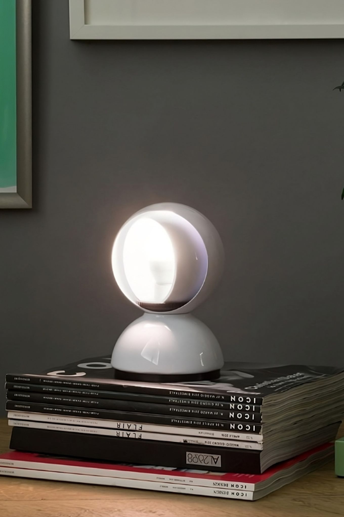 The Eclisse lamp from Artemide stands on a stack of books. 