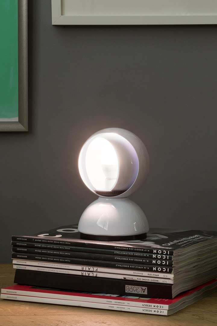 The Eclisse lamp from Artemide stands on a stack of books. 