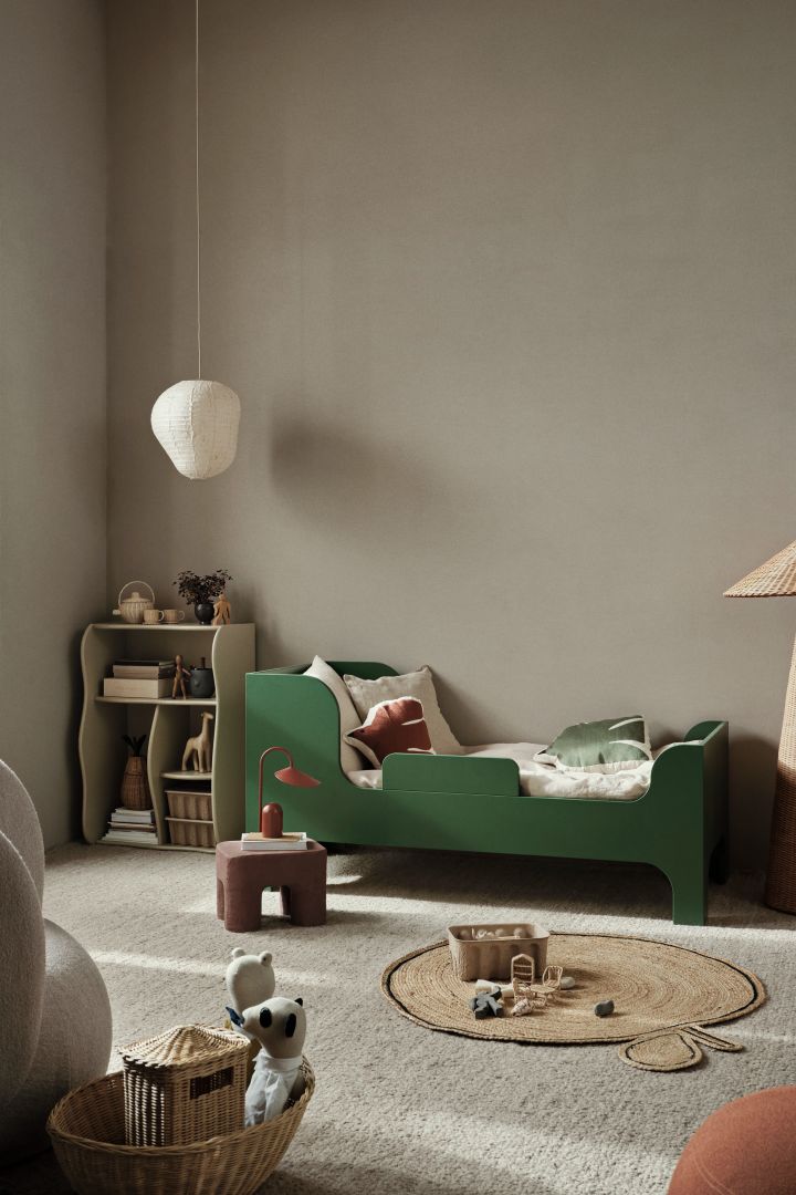 A children's room with neutral walls and a green bed. Coloured furniture is a great way to bring colour into a children's bedroom. 