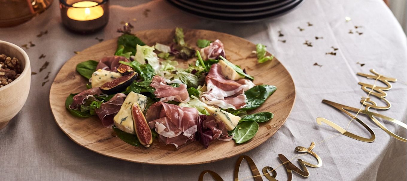 We have 4 simple starter recipes for your new year's party for you to try. A delicious prosciutto and blue cheese salad next to a Happy New Year sign.  