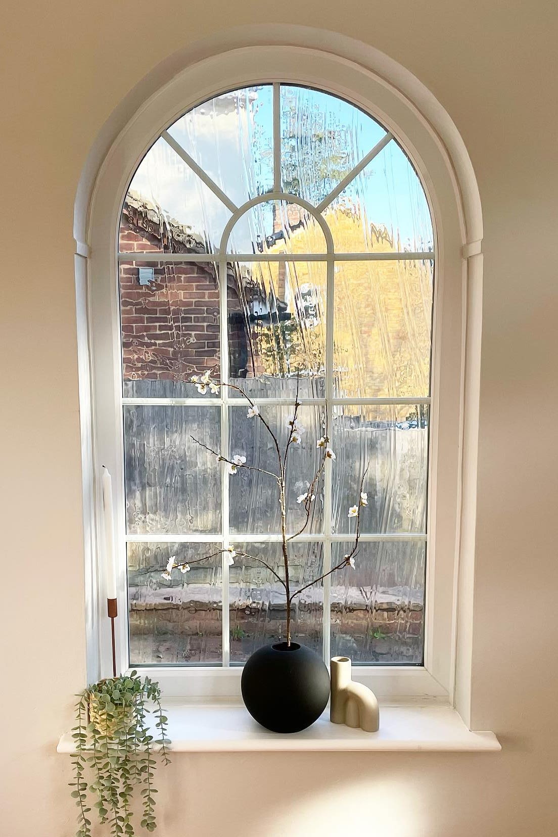 Here you can see the pretty arched window with window sill by @abrysonhouse, which is decorated with candlesticks and the black ball vase from Cooee Design with spring flowers.