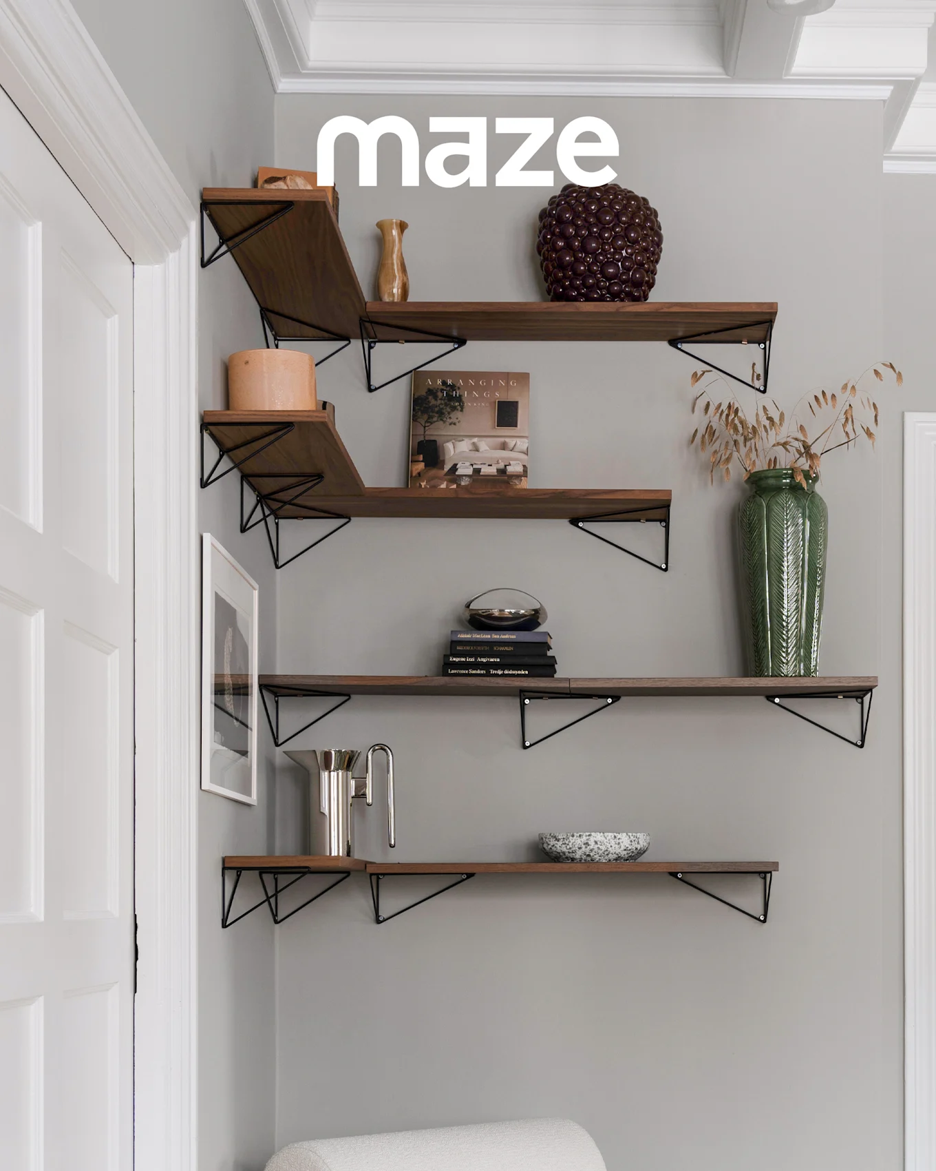 White tree-shaped coat rack with wooden knobs in a child's room with a crib and toys. Brand 'maze' is visible.