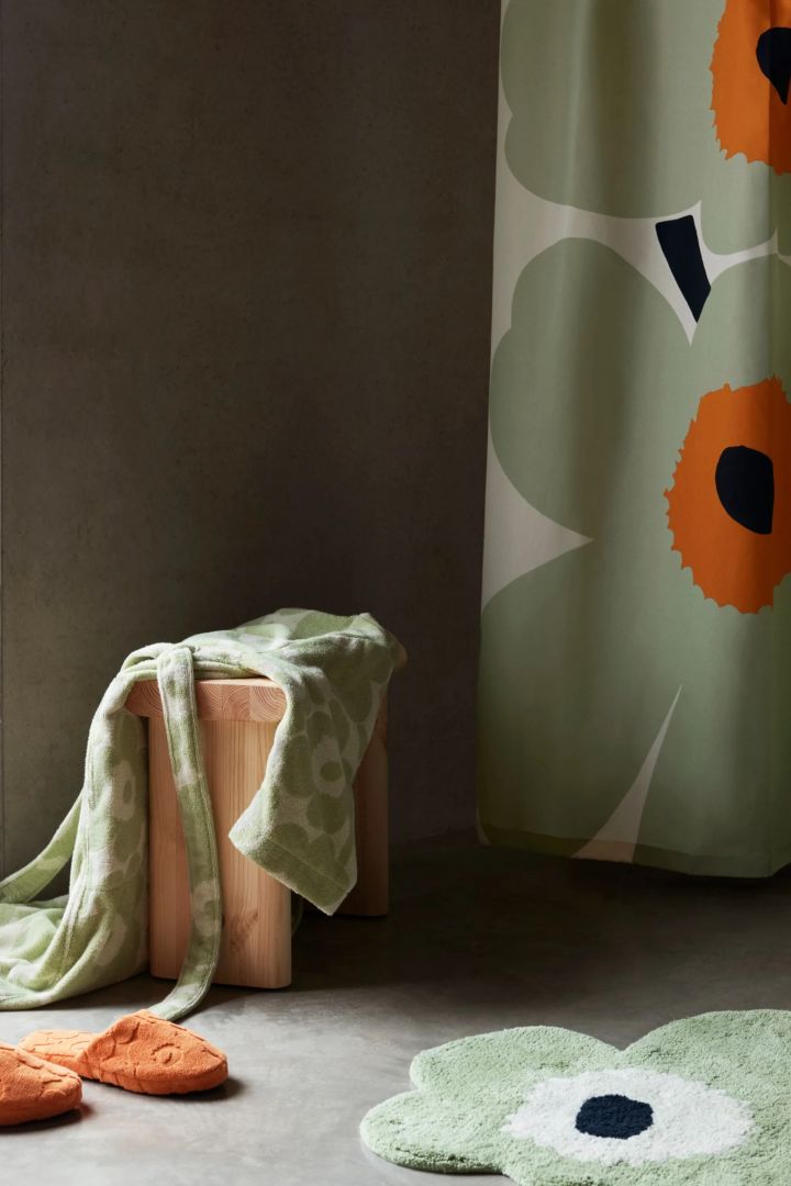 Unikko shower curtain, bathrobe, slippers and bathroom mat in green, products that are part of the 60th anniversary of Unikko.