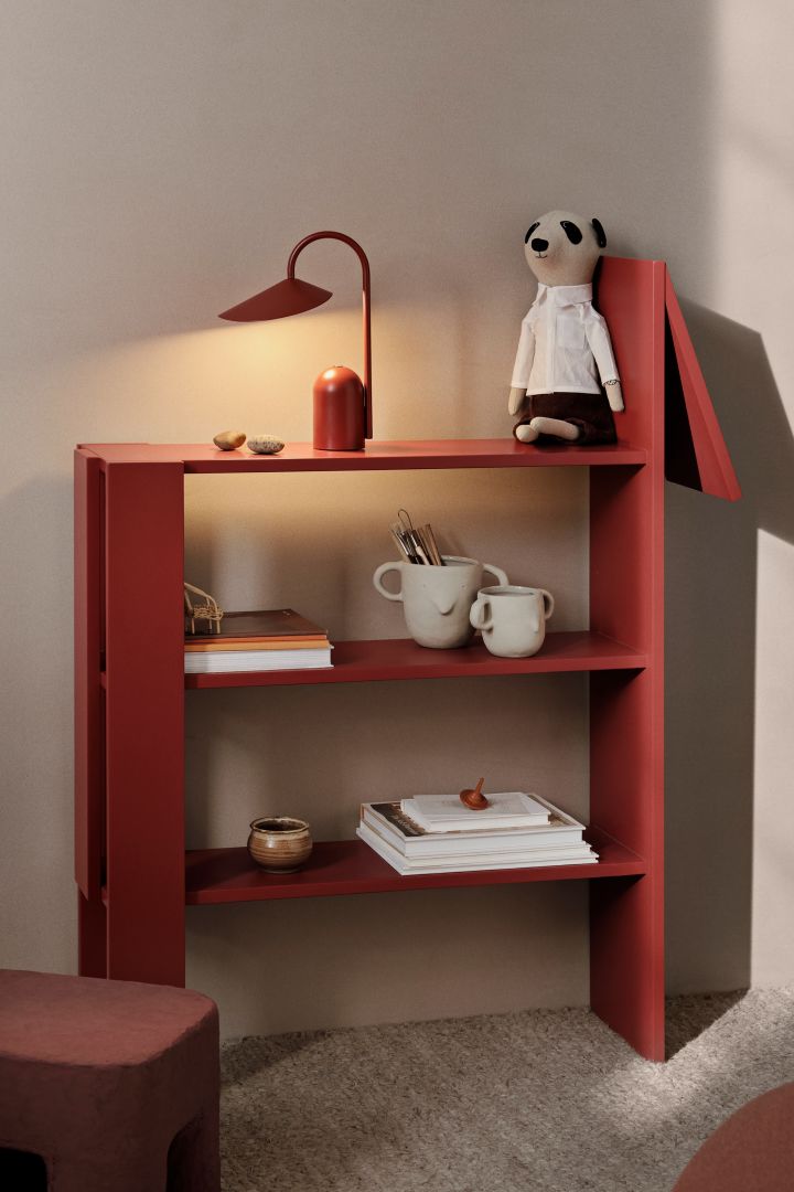 Adding colour is a great idea for the children's room. Here you see the Giraffe shelf from Ferm Living in a bright pop of red, decorated with a red portable lamp and some soft toys. 