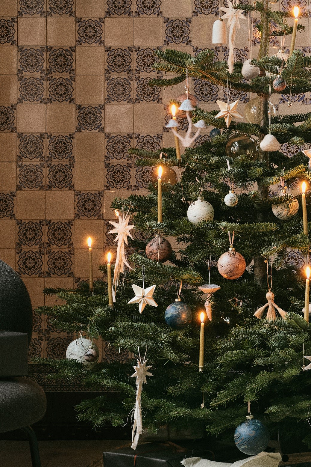 Natural Christmas tree decoration ideas from ferm LIVING. Here you see a tree decorated with felt stars, bells and mushrooms in natures colour palette.