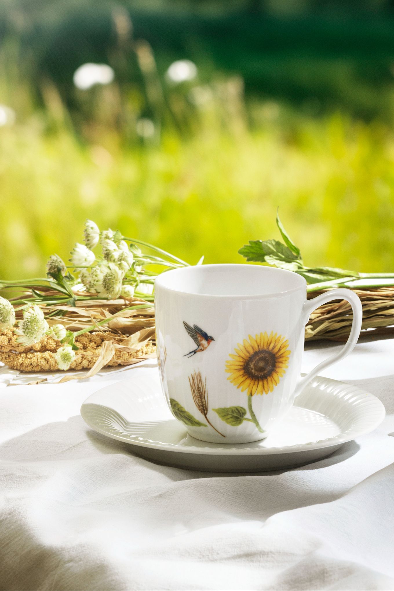 The Hammershoi summer collection sunflower mug stands on a table in the sunshine. 