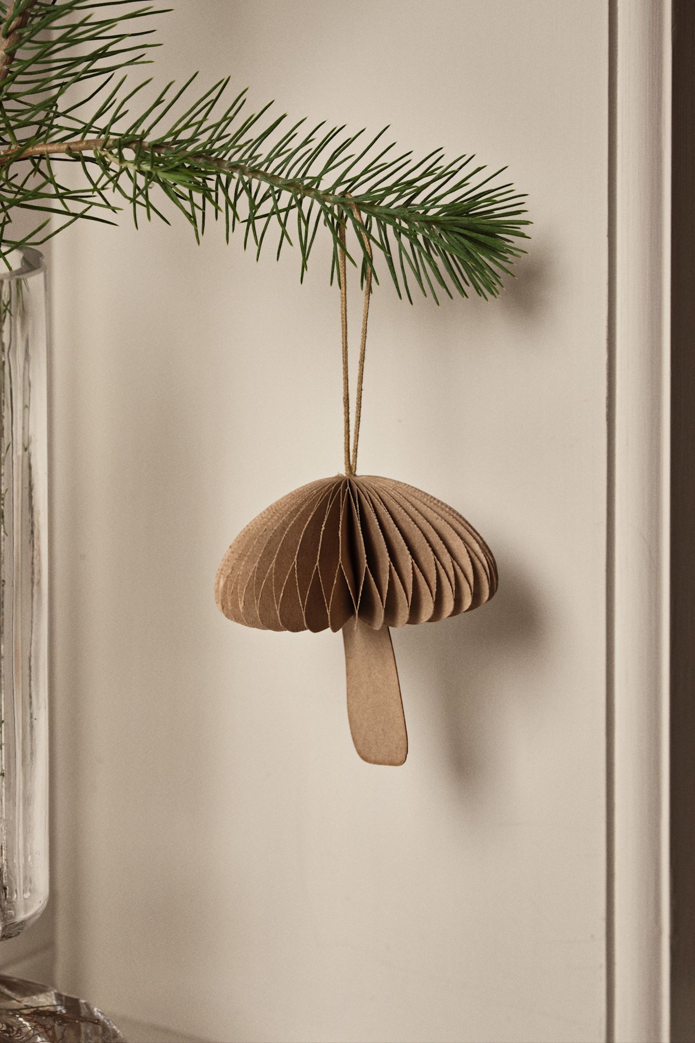 Nature inspired Christmas tree decoration ideas like the Fungi mushroom decoration from Broste Copenhagen seen here hanging on a branch. 