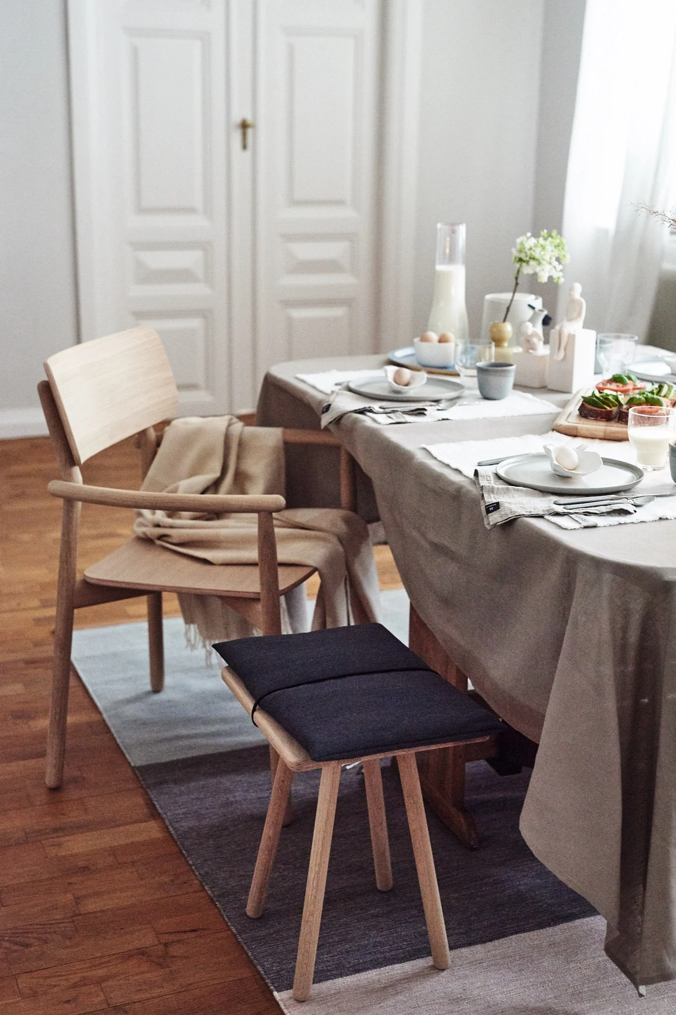 Skagerak Georg stool oak,Design House Stockholm Fields rug, Paradisverkstaden Morgon grey plate,Scandi Living Clean tablecloth,Elvang Denmark Elvang Luxury throw