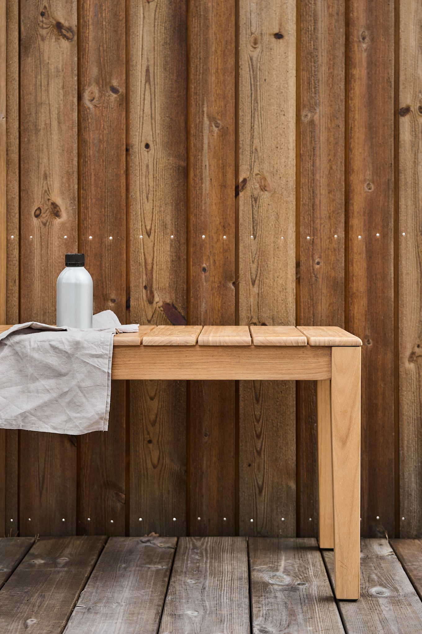 Here you see a hand cleaning a piece of teak furniture with a cloth. 