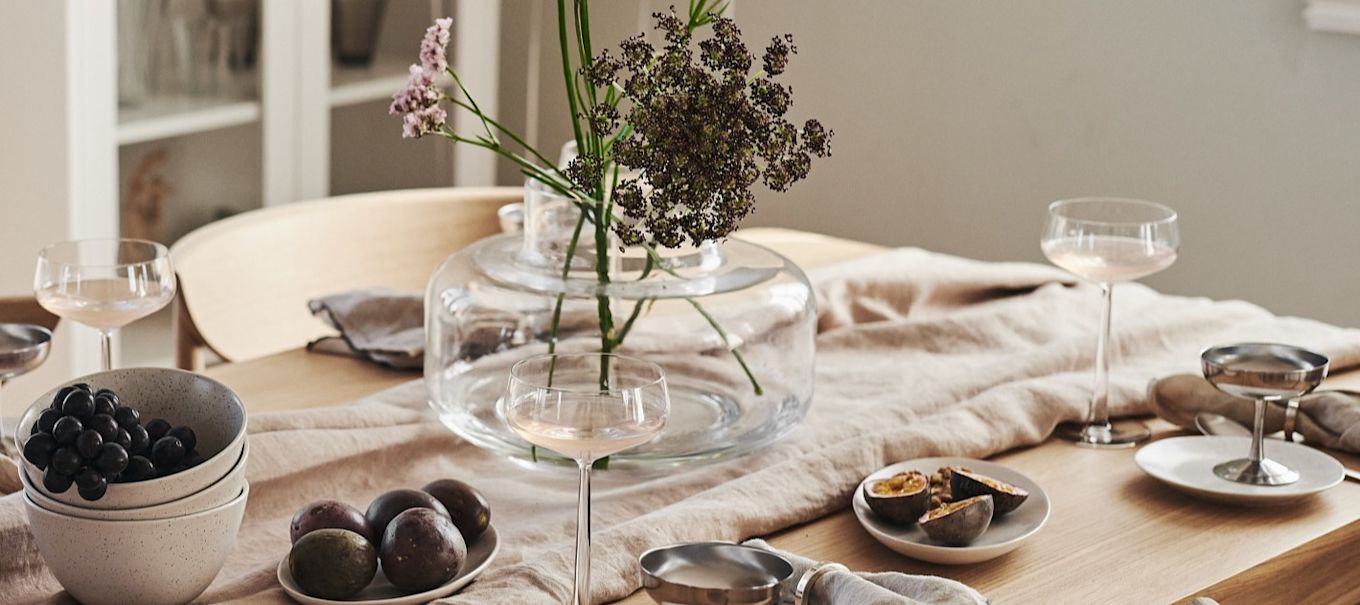 A romantic table setting with plates and bowls from By On together with elegant champagne glasses from Blomus.