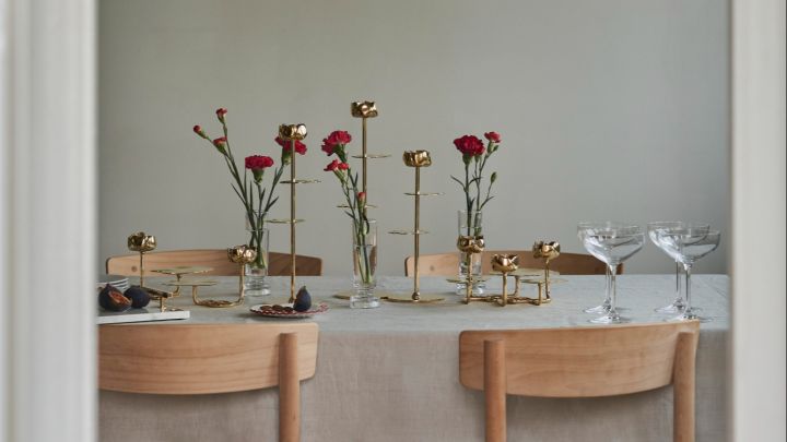 Here you can see a dining table decorated with Hilke candlesticks and red flowers.