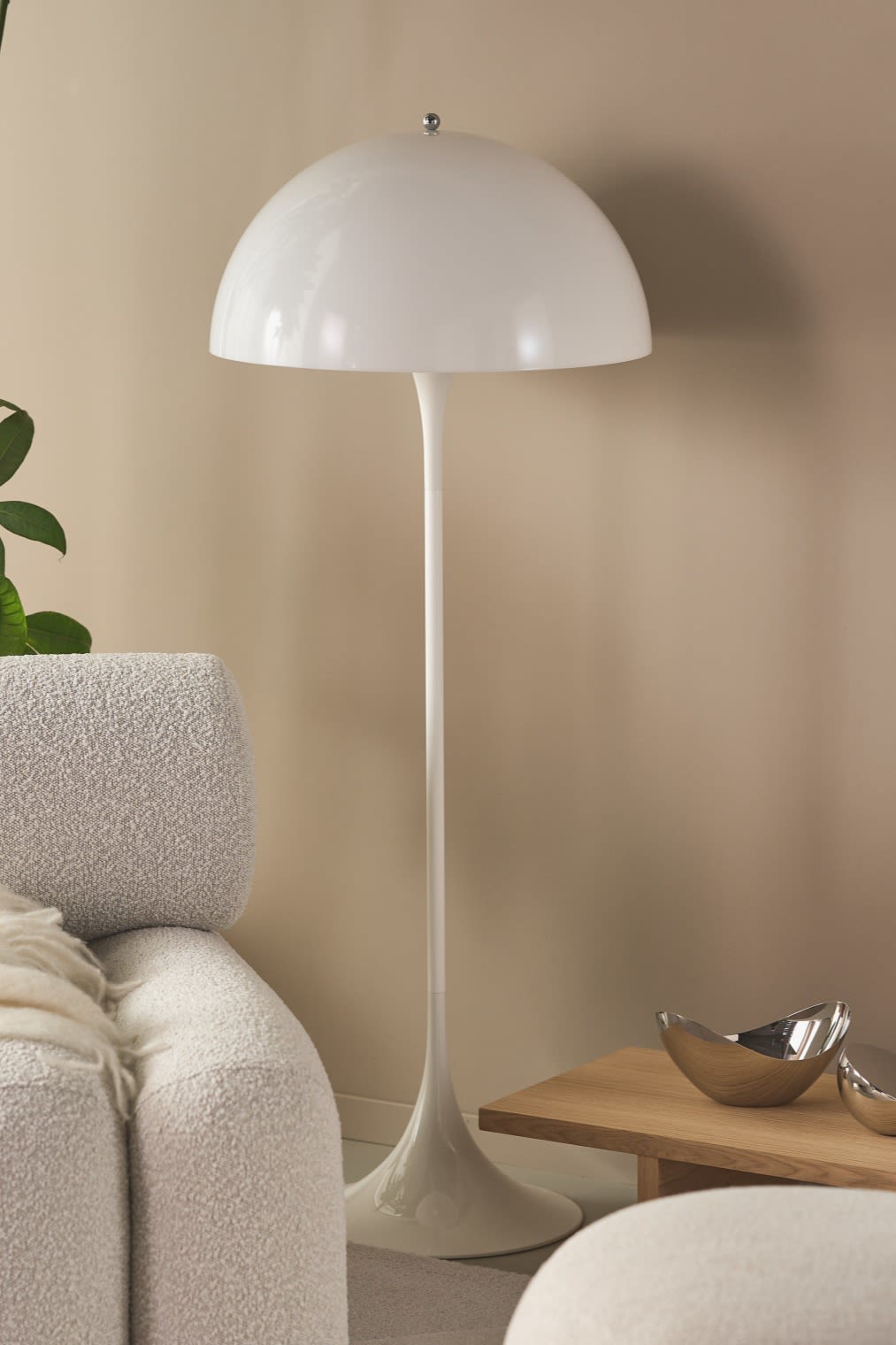 Renew your home with modern floor lamps - here you see Pathella floor lamp in a beige living room with green plants and chunky furniture. 