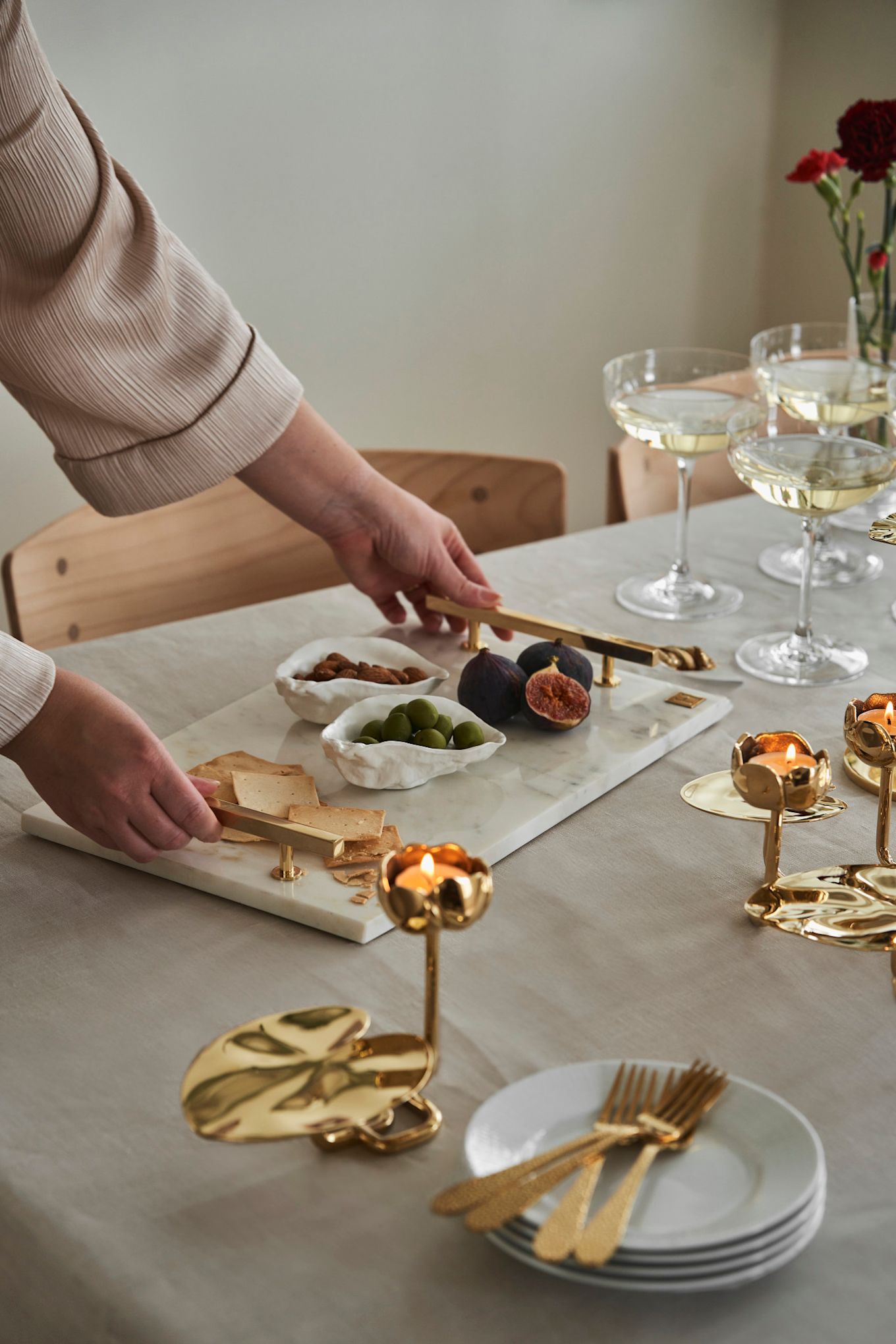 Treat your friends to an afternoon tea this Galentine's Day. Here you see a marble tray from Hilke Collection alongside some gold candle holders in the shape of a water lily. 