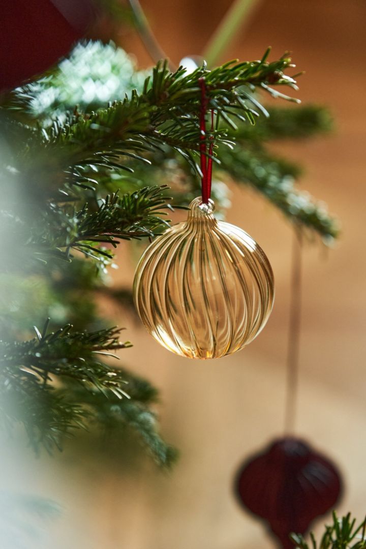 Here you see the gold Clarity bauble from Scandi Living hanging in a tree. Glass decorations are as popular as ever in 2024. 