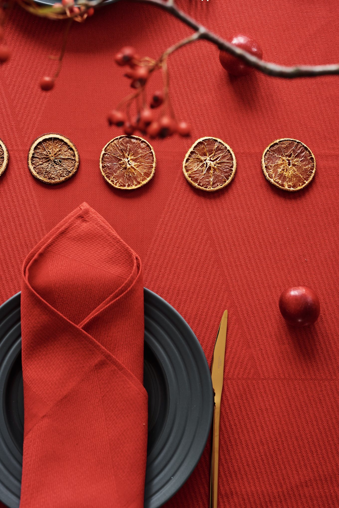 Red table setting for Christmas with red linen napkin and linen table cloth as well as grey plates from NJRD.