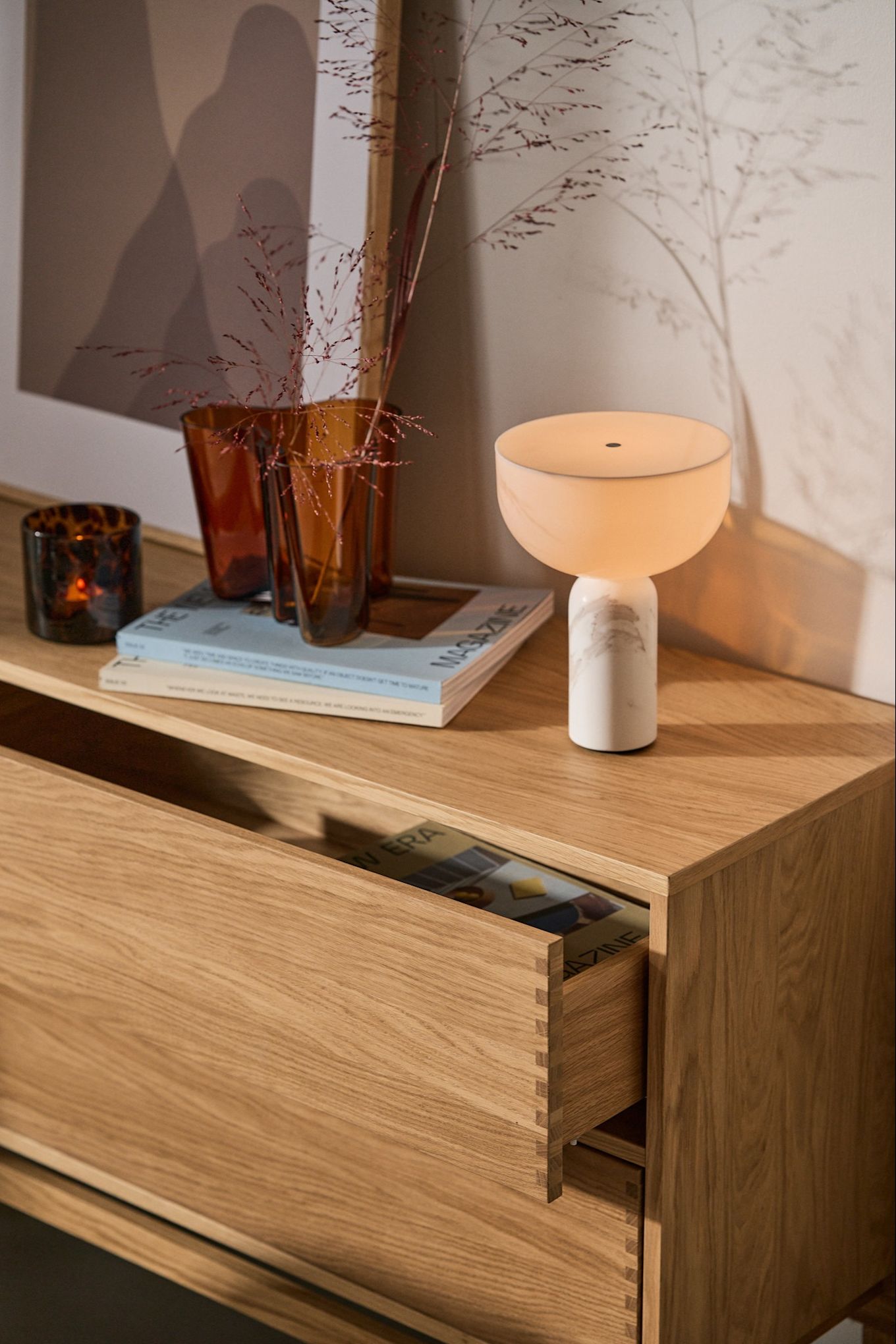 Refresh your home with these modern lighting ideas. Here you see the portable Kizu lamp from New Works, on a wooden sideboard.