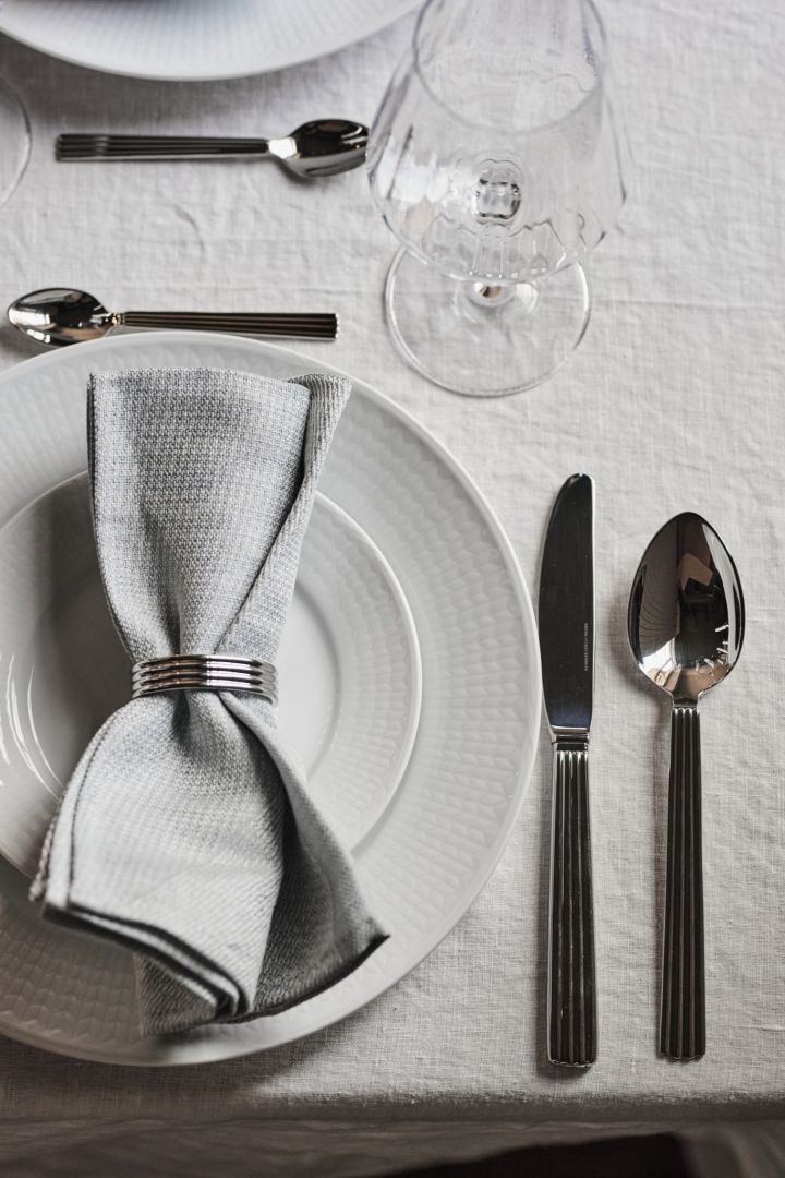 Here you see a white table setting idea from above with white and chrome details such as Swedish Grace plates and Bernadotte cutlery.