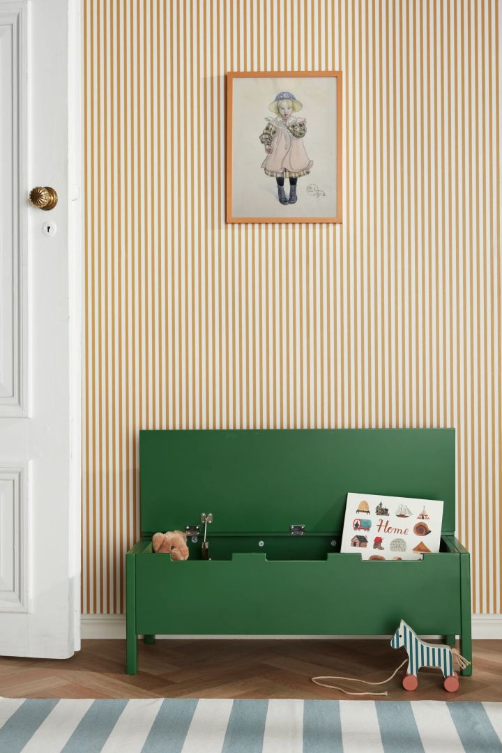 A green toy box in a pale yellow children's room. Ideal for organising a messy children's room. 