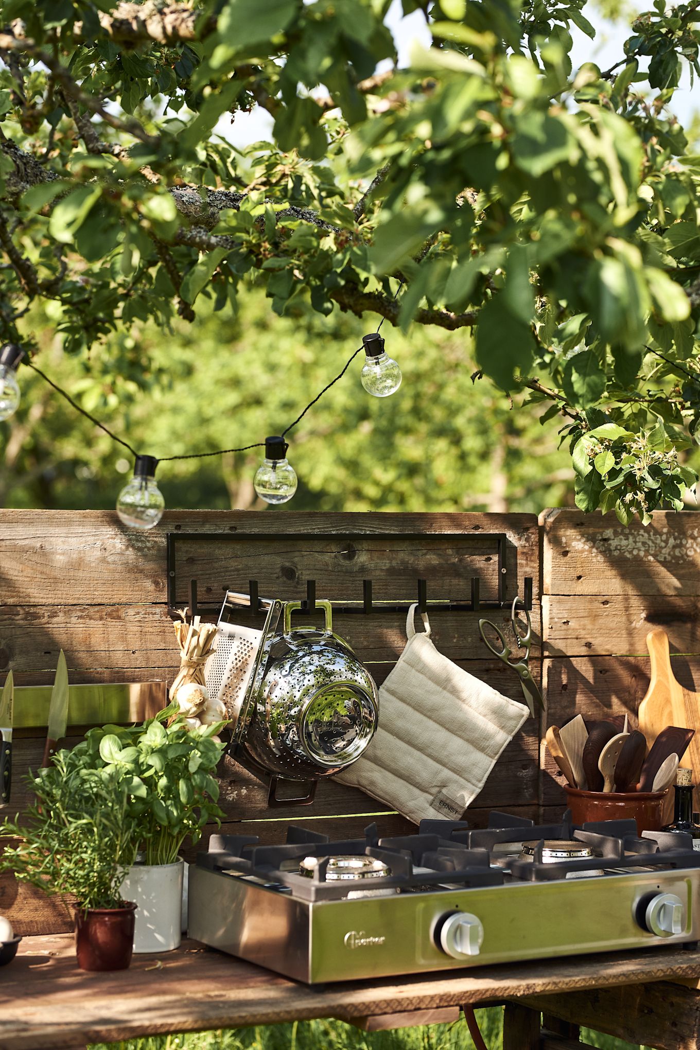 The back wall of your DIY outdoor kitchen is perfect for hanging utensils that you need to have easily available.