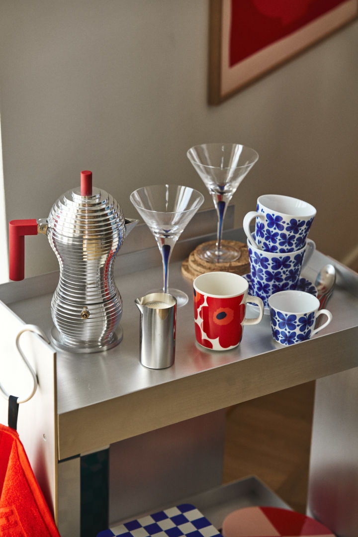 Here you see a retro coffee station in chrome with blue and red mugs and blue cocktail glasses, nostalgic interior design is one of the biggest trends in autumn 2024. 