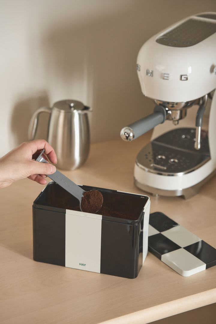 To keep your coffee bar tidy, it's best to pour the coffee into the pretty black and white Tin Container from Hay, which you can see here in front of the Smeg espresso machine.