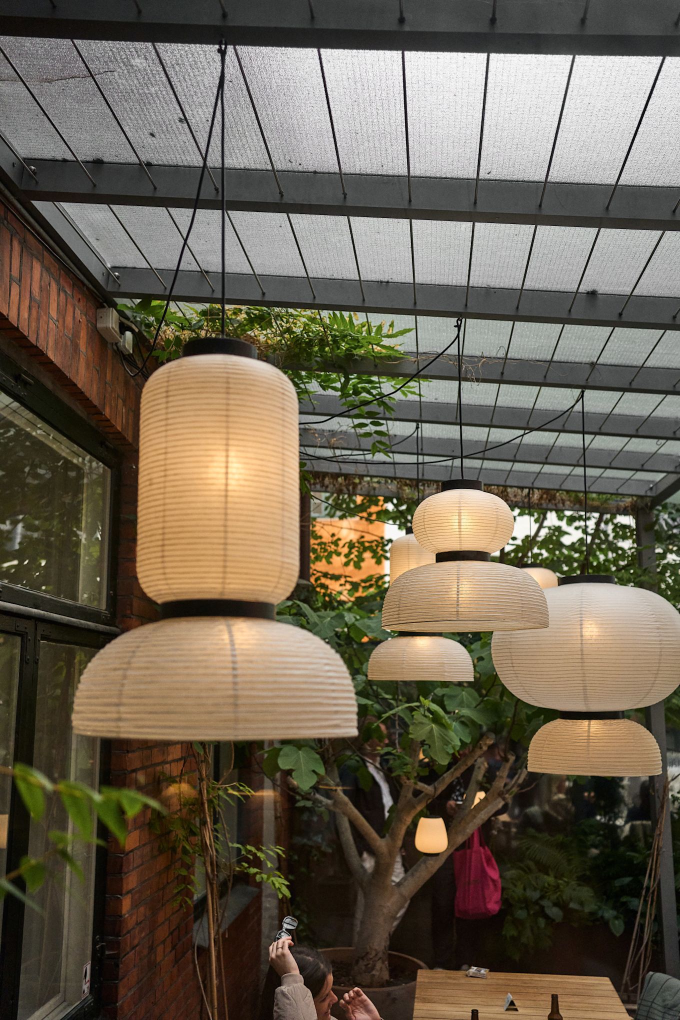 The Lille Petra Cafe is the ideal place to stop for lunch on a Copenhagen city tour for design lovers. Here you see the Formakami paper lamps hanging in court yard in the summer months. 