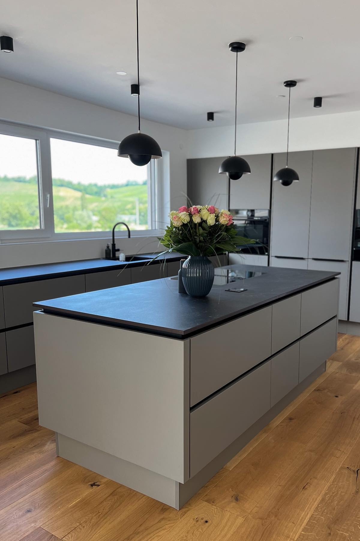 Place several pendant lights to provide sufficient lighting in the kitchen, here you can see three Flowerpot pendant lights from &tradition hanging above a grey and black kitchen island in @lenuslenix's home.