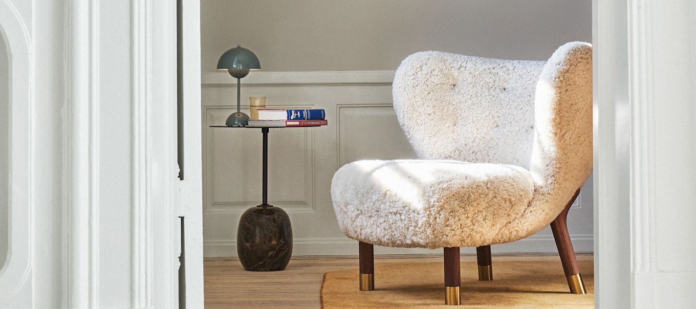 A living room decorated with products from &Tradition, here you see the Little Petra arm chair, the Lato side table and the VP9 cordless Flowerpot table lamp all in a dark wood for a retro feeling. 