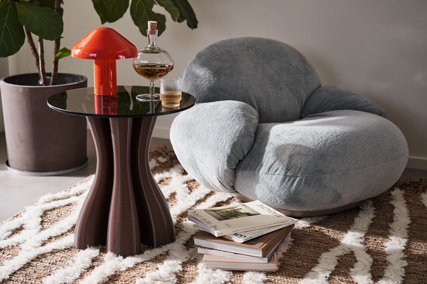 Maximalism is taking over our homes according to interior design trends in 2024, here an eclectic living room with Pacha armchair from Gubi, coffee table from Ekbacken Studios and red portable lamp from HAY.