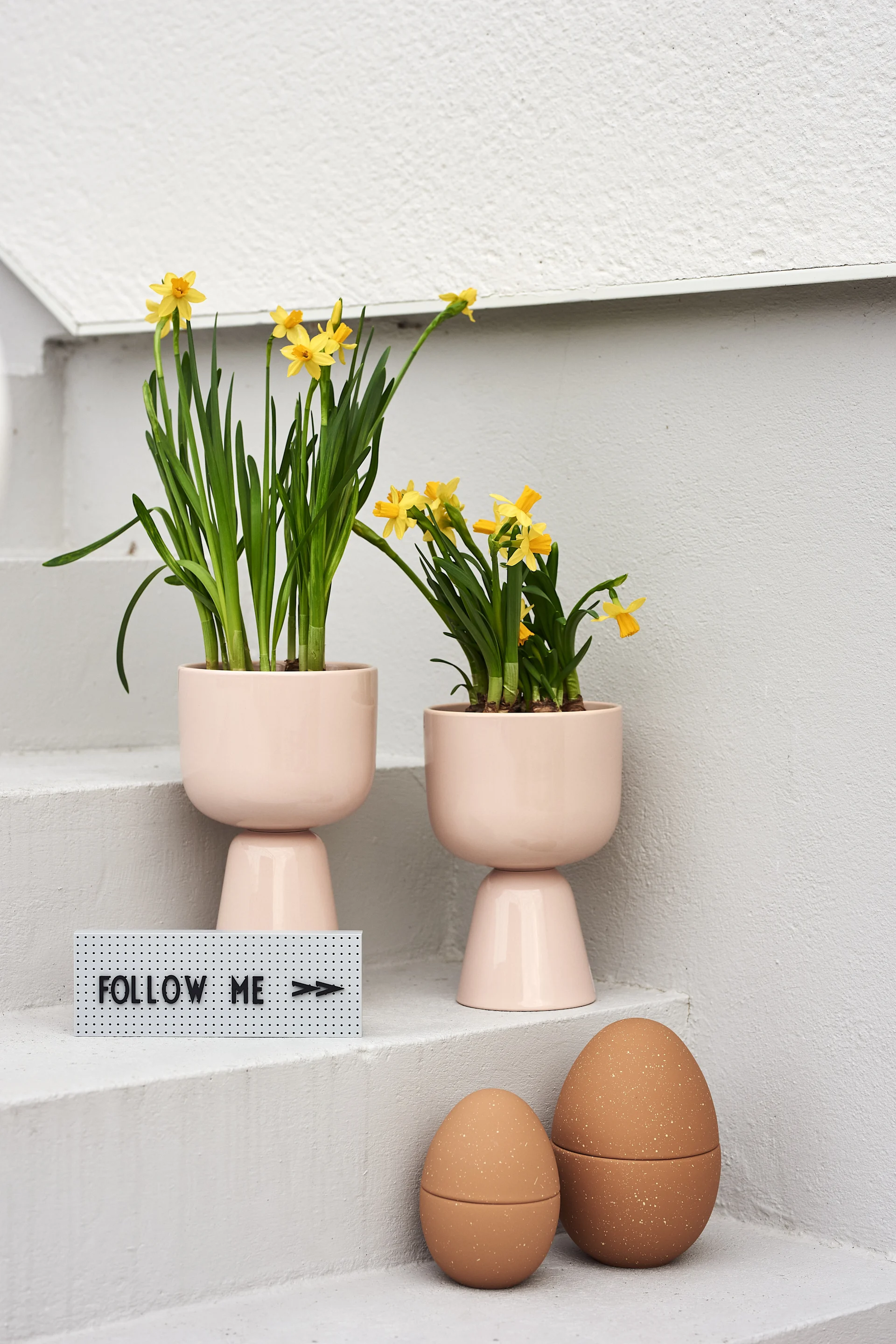 How to organise an egg hunt with clues this Easter - The Design Letters sign shows the way to two eggs from Cooee Design filled with Easter goodies.