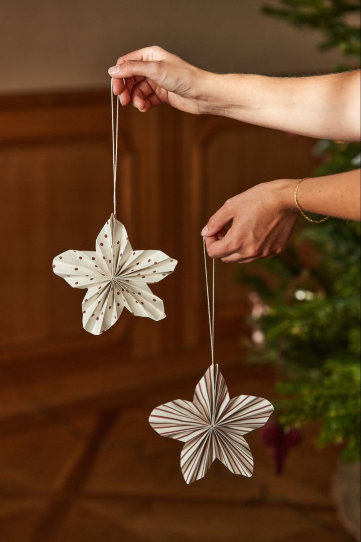 A pair of hands hold the folded star Christmas tree decoration ideas Twinkle from Scandi Living. 