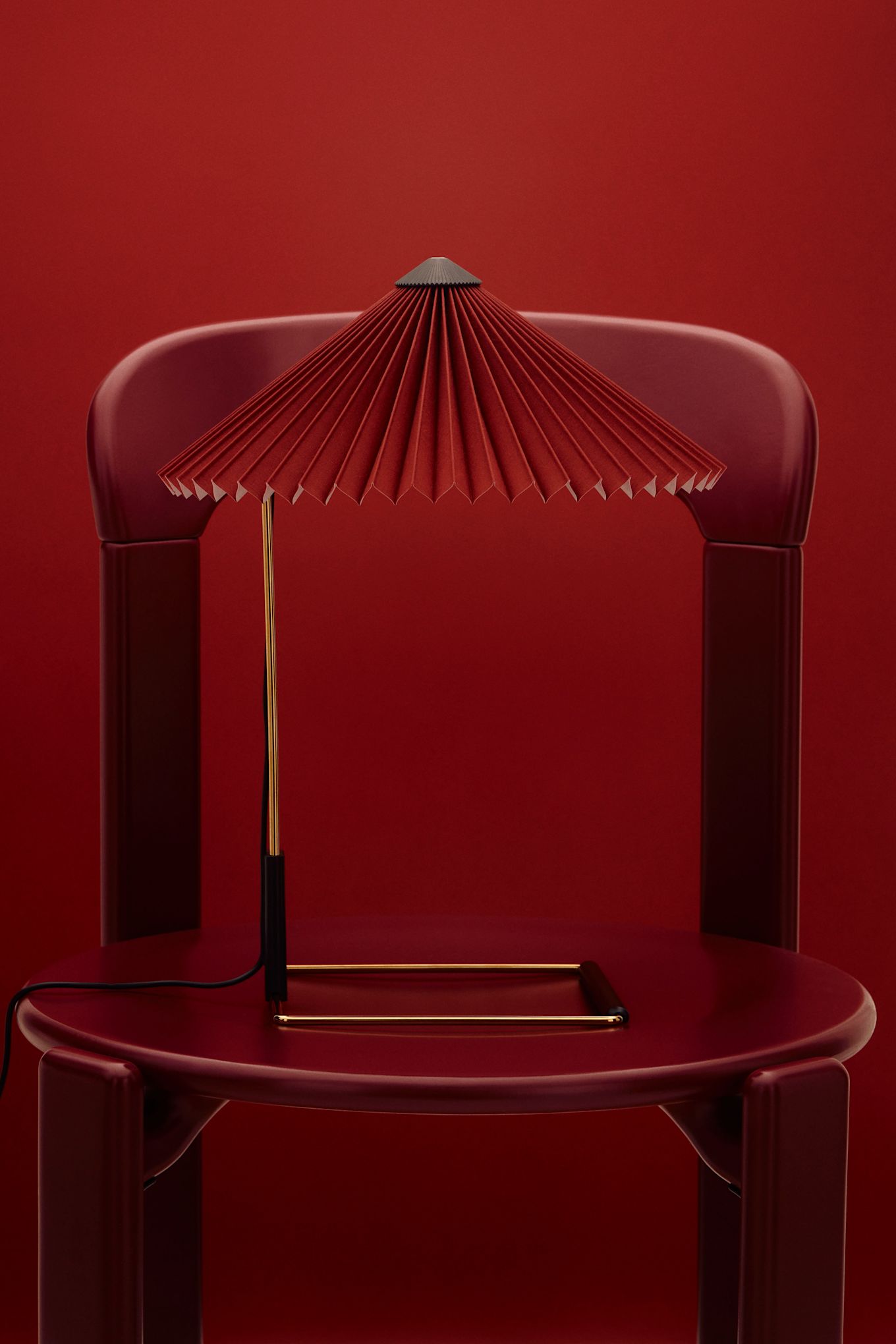 Cherry red is one of the interior colour trends of 2025, here you see the Matin lamp on a red chair against a background in the same tone. 