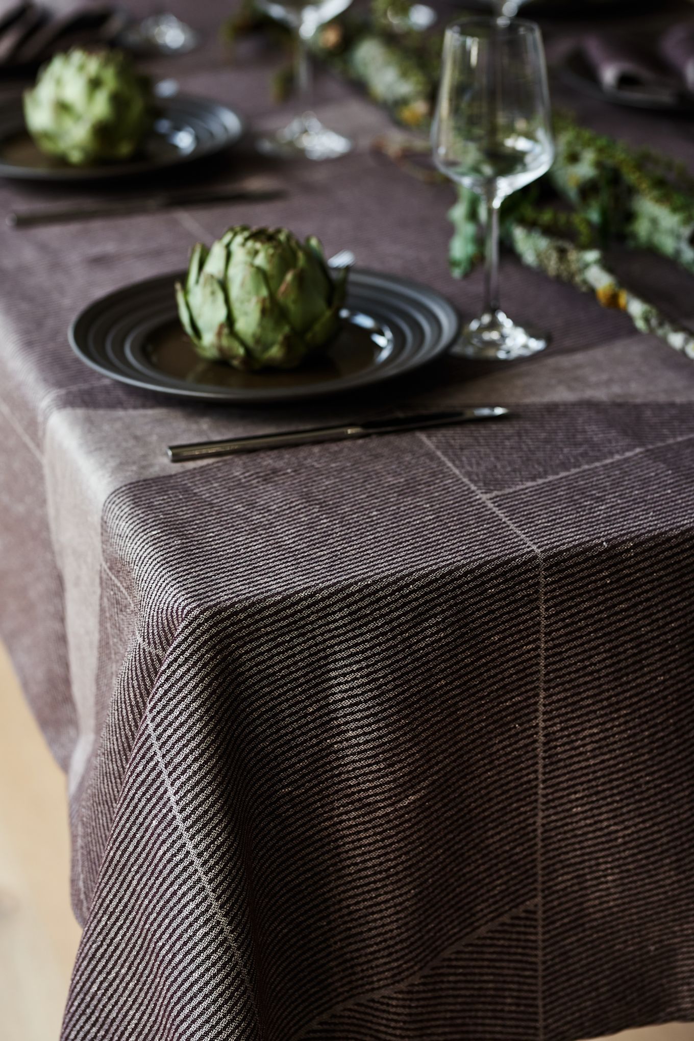 A brown table cloth from NJRD with the brown Lines plate also from NJRD on an elegant and rustic table setting.