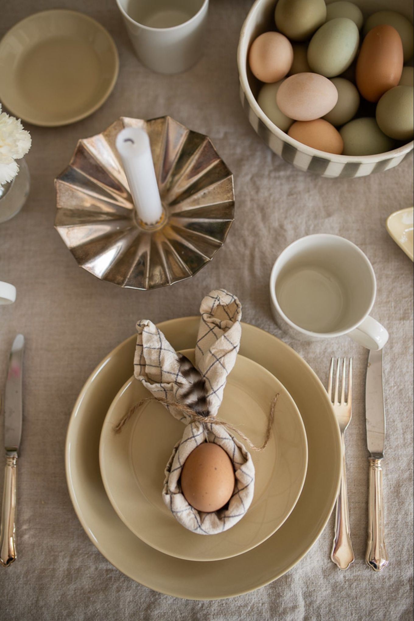 A napkin folded into a set of bunny ears with an egg nestled into the centre. 