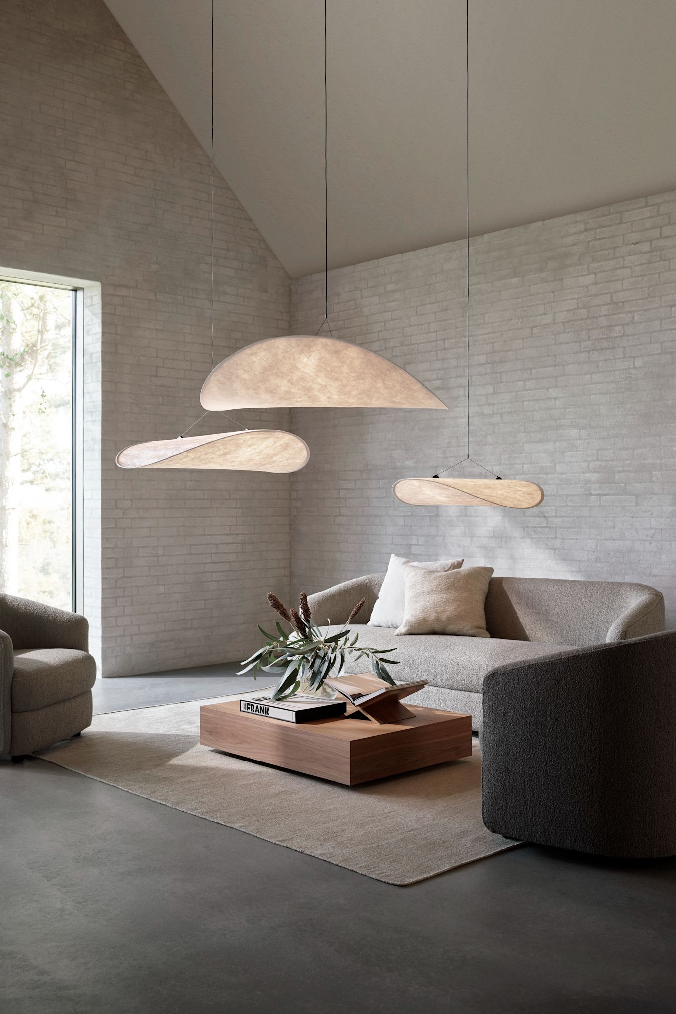 A large living room with three Tense pendant lamps hanging above the sofa in a group.