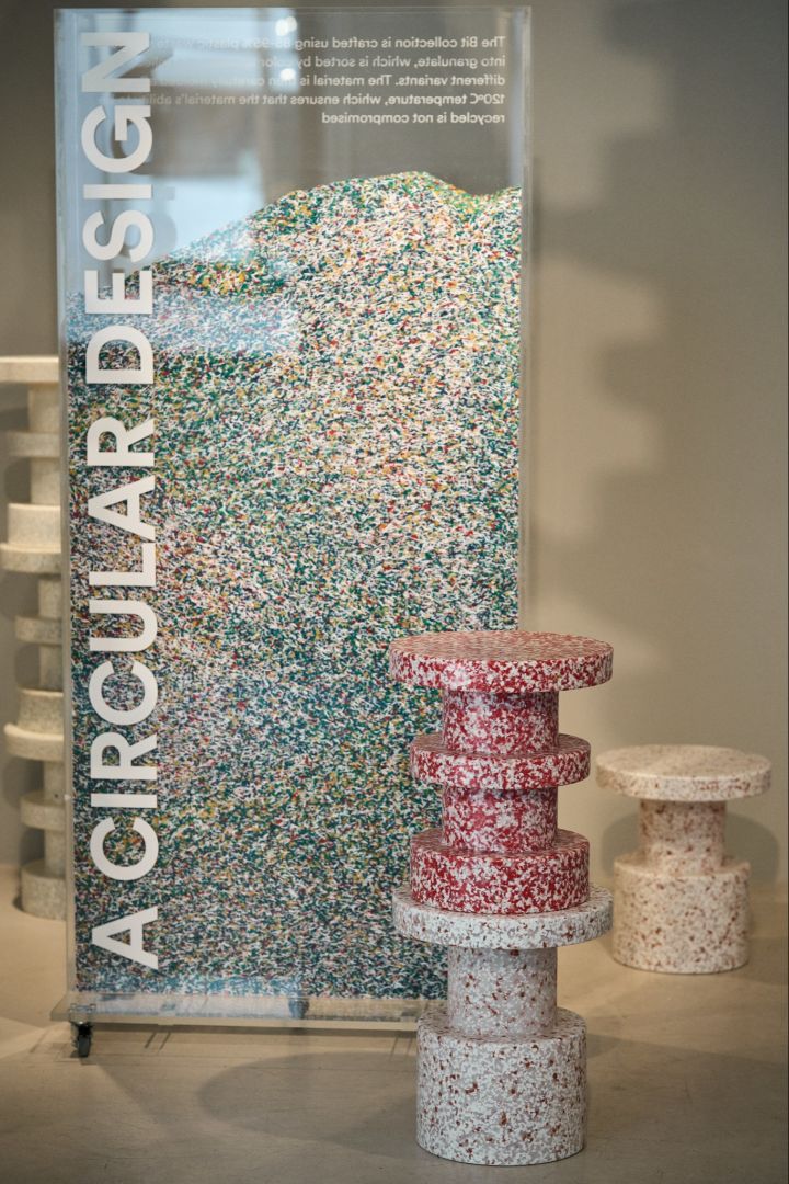 Normann Copenhagen is a must visit on any Copenhagen city tour for design lovers. Here you see an image of two Bit stools standing next to a clear cabinet filled with the pieces of recycled plastic that will eventually be used to make the stools. 