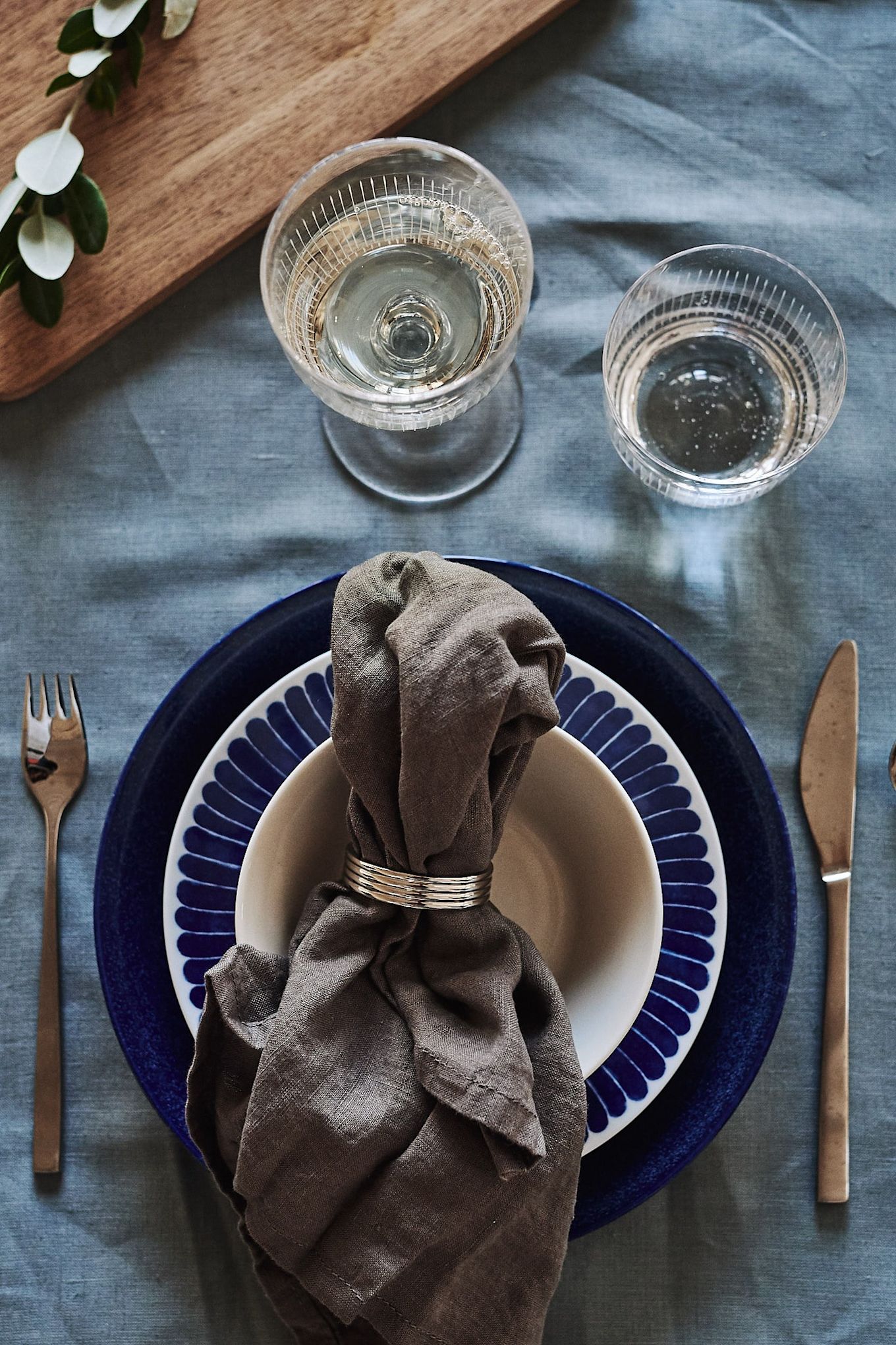 A blue and white table setting welcomes guests to the table with its grain blue shade and plate from Iittala, Götefors porcelain and Nordic Nest.