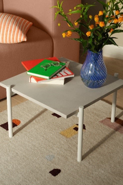 Blue vase, striped pillow in peach colors and gray coffee table from Broste Copenhagen.