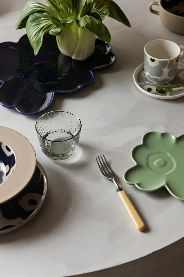 Set with Unikko porcelain from Marimekko, including two flower-shaped plates in mint green and dark blue.