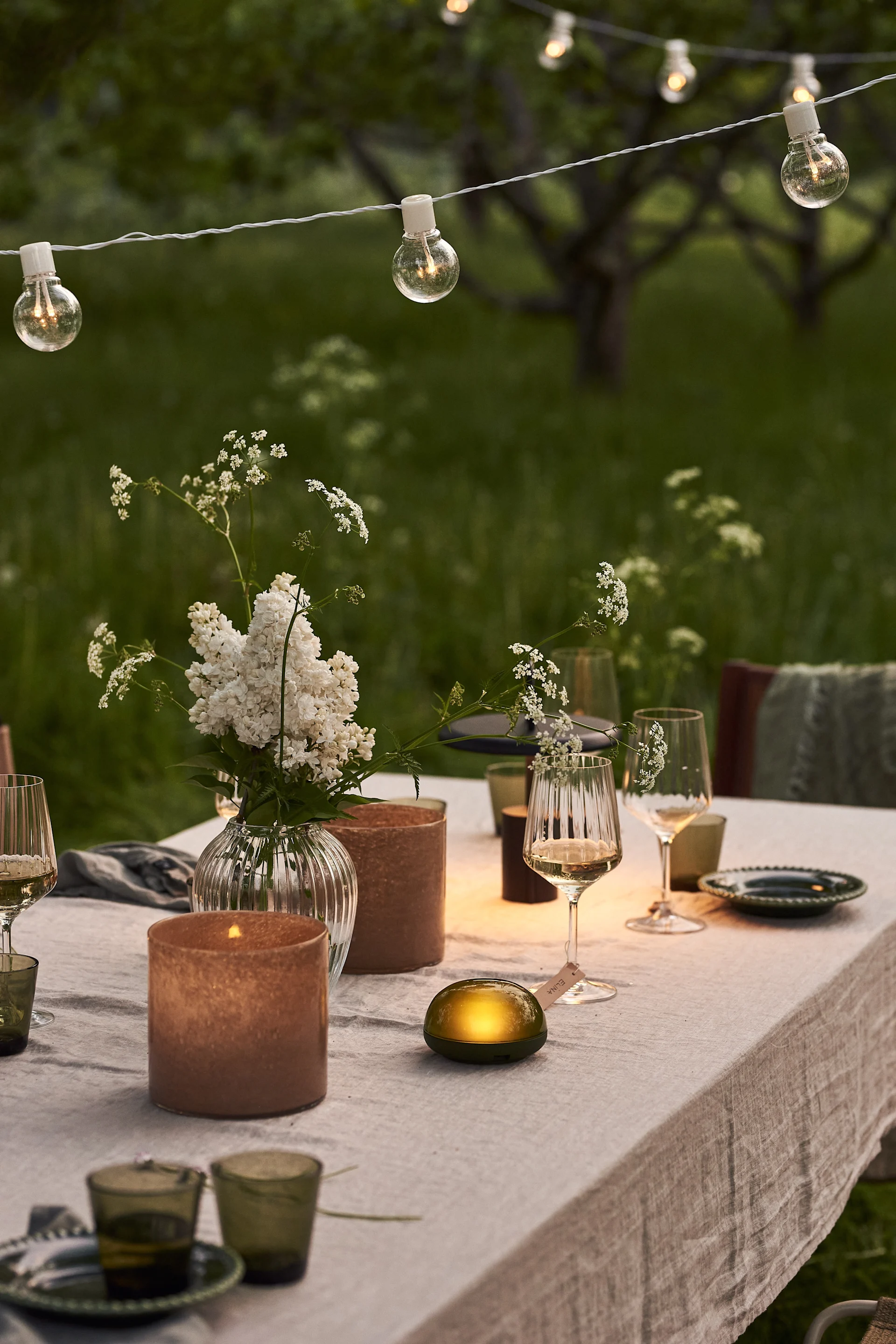 Discover our garden party inspiration - string lights are a playful and cosy element for your outdoor dining experience.