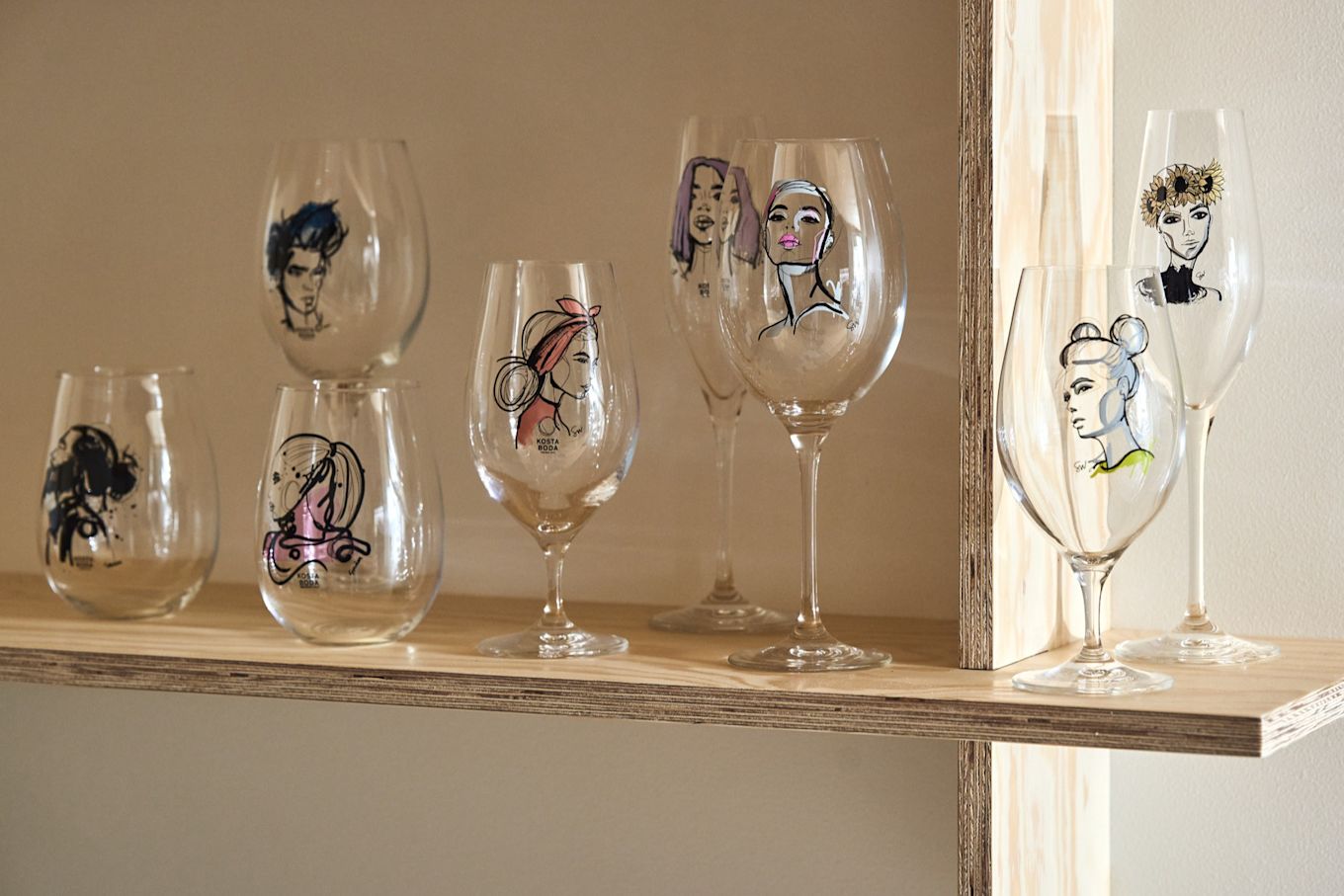 A collection of glasses from the All about you collection stand on a plywood shelf.  