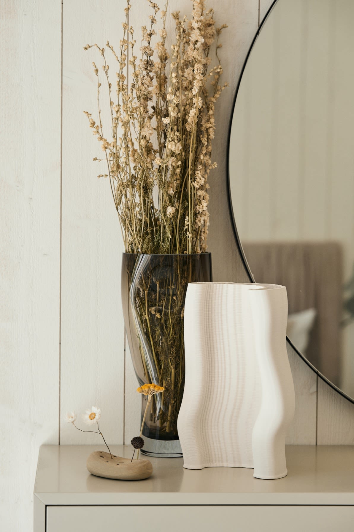 The 3D printed Moire vase from ferm LIVING stands on a dresser with a vase of dried flowers. Structured and tactile materials will be a big trend in the autumn of 2024.