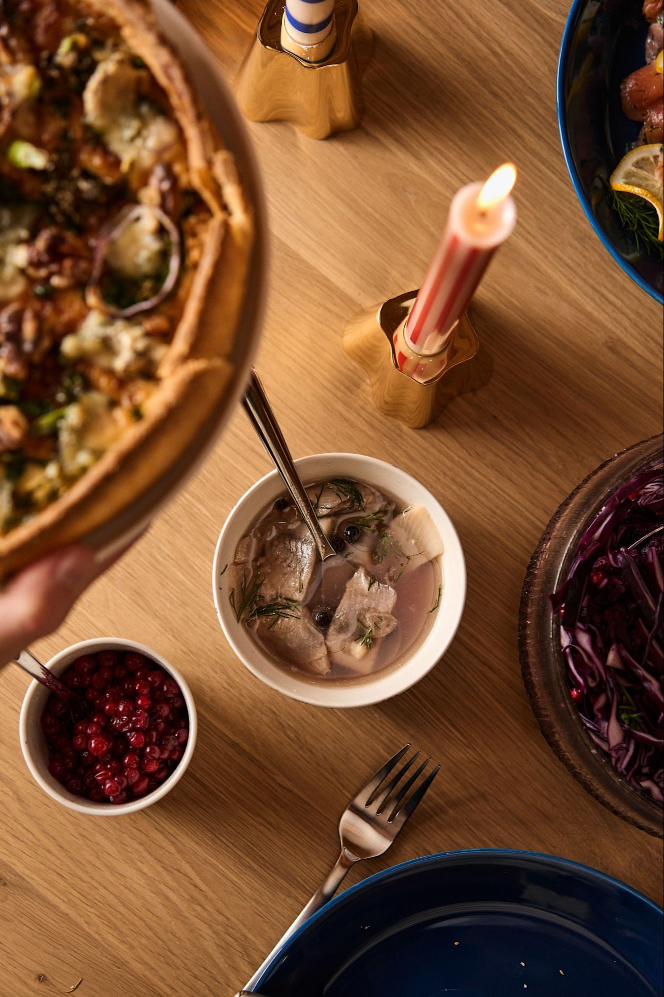 A jar of traditional Swedish ligon berries and pickled herring on a Nordic Christmas table.