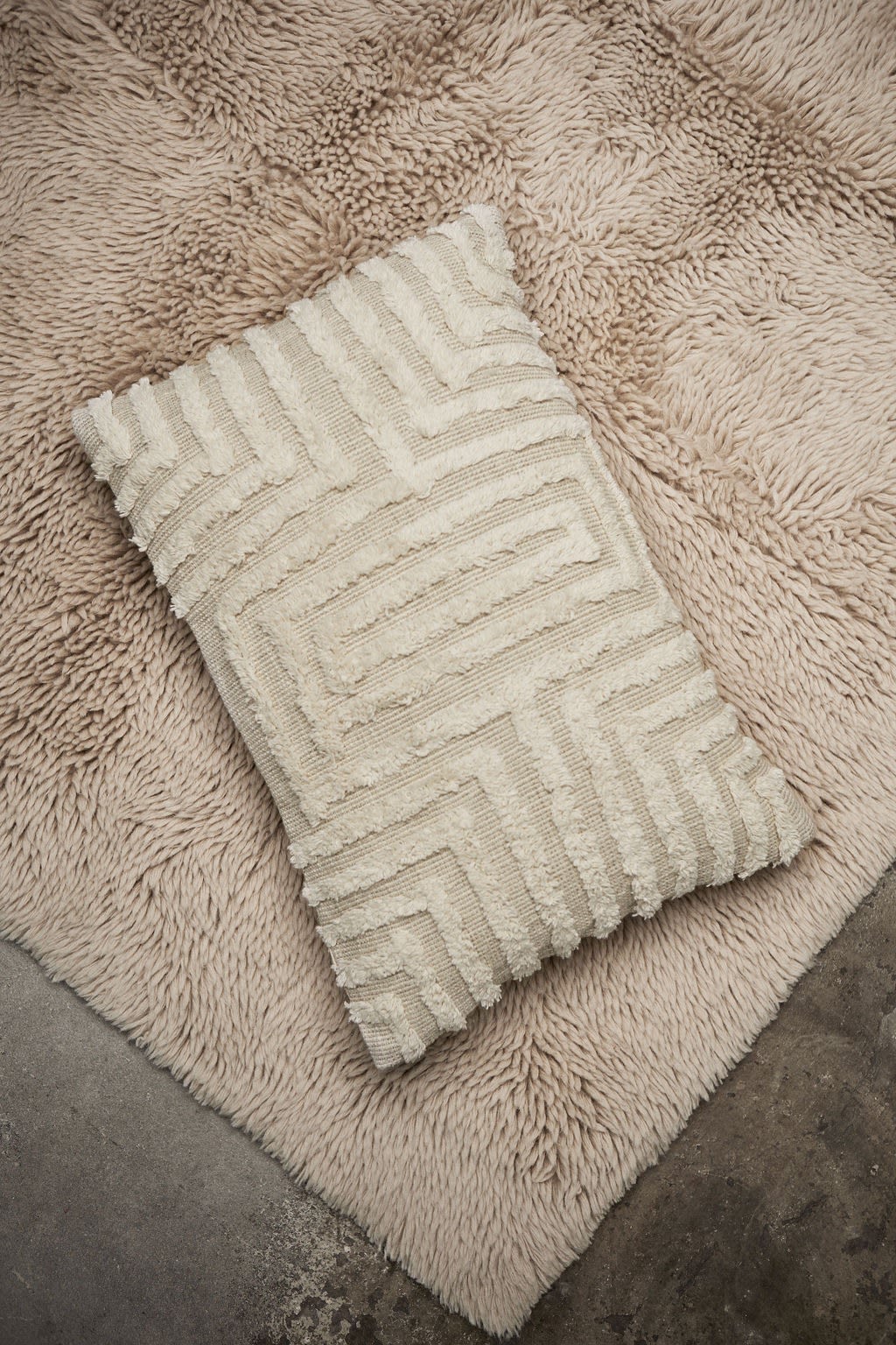 Here you see a beige cushion from Swedish brand Tinted Objects with a raised fluffy squared shaped pattern. 