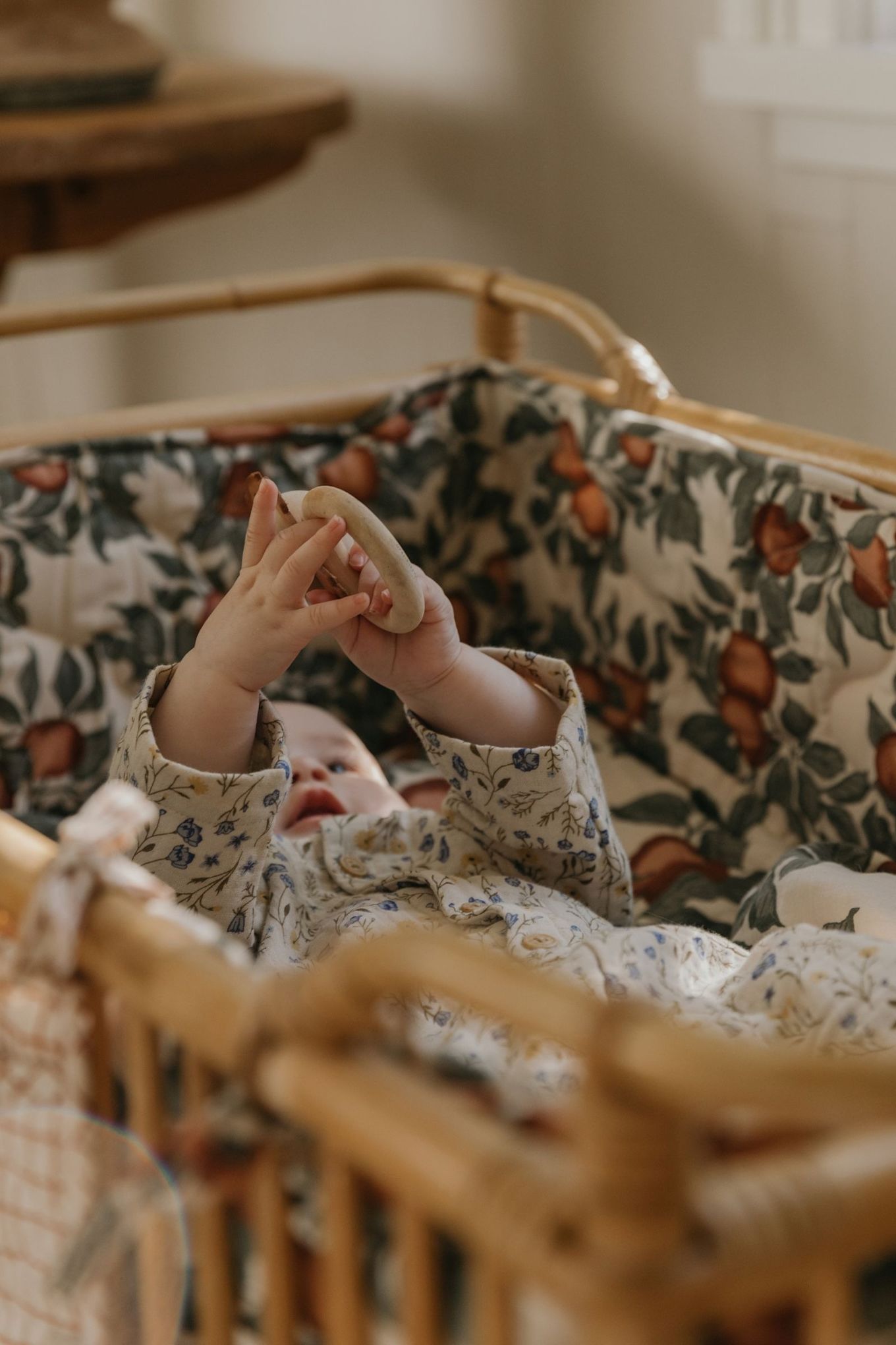 A baby lays in a crib surrounded by the Garbo&Friends crib bumper a lovely baby shower gift idea. 