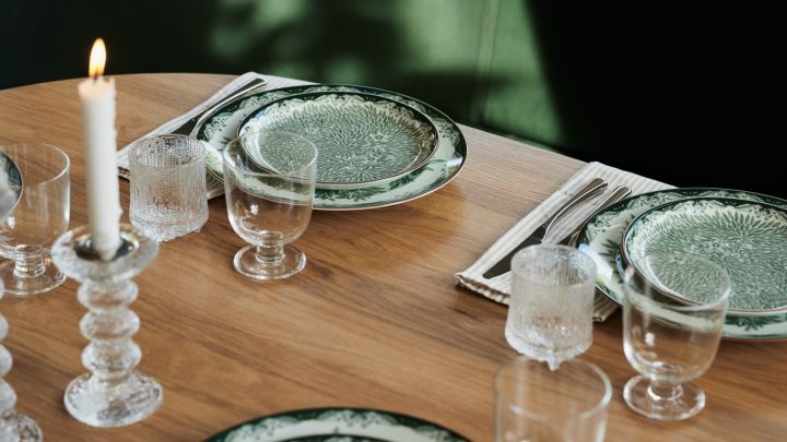 Design classic Ostindia floral tableware in green in a restaurant style table setting with chunky glass candle holders. 