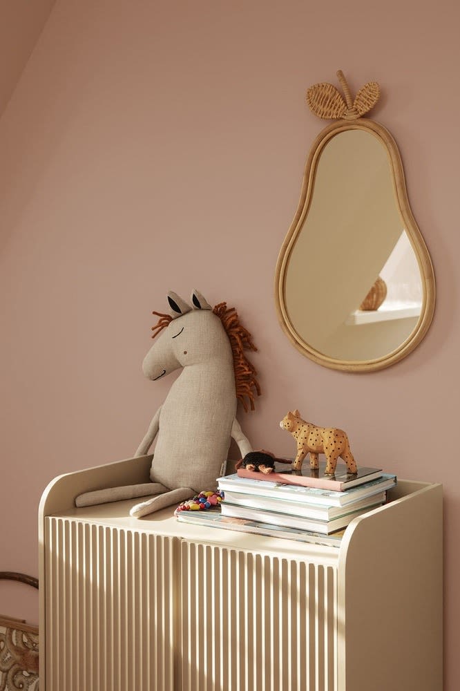 The Safari horse cushion from Ferm Living sits on a chest of drawers in a children's room, with the Pear mirror hanging next to it, both would be great baby shower gift ideas. 